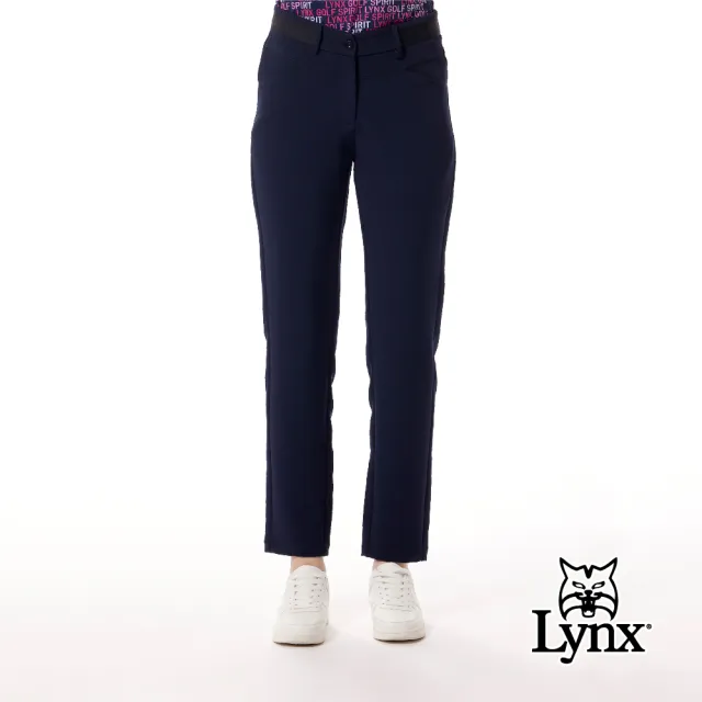 【Lynx Golf】女款彈性舒適壓紋織帶剪接質感金屬貼膜造型前低後高腰圍設計窄管長褲(二色)